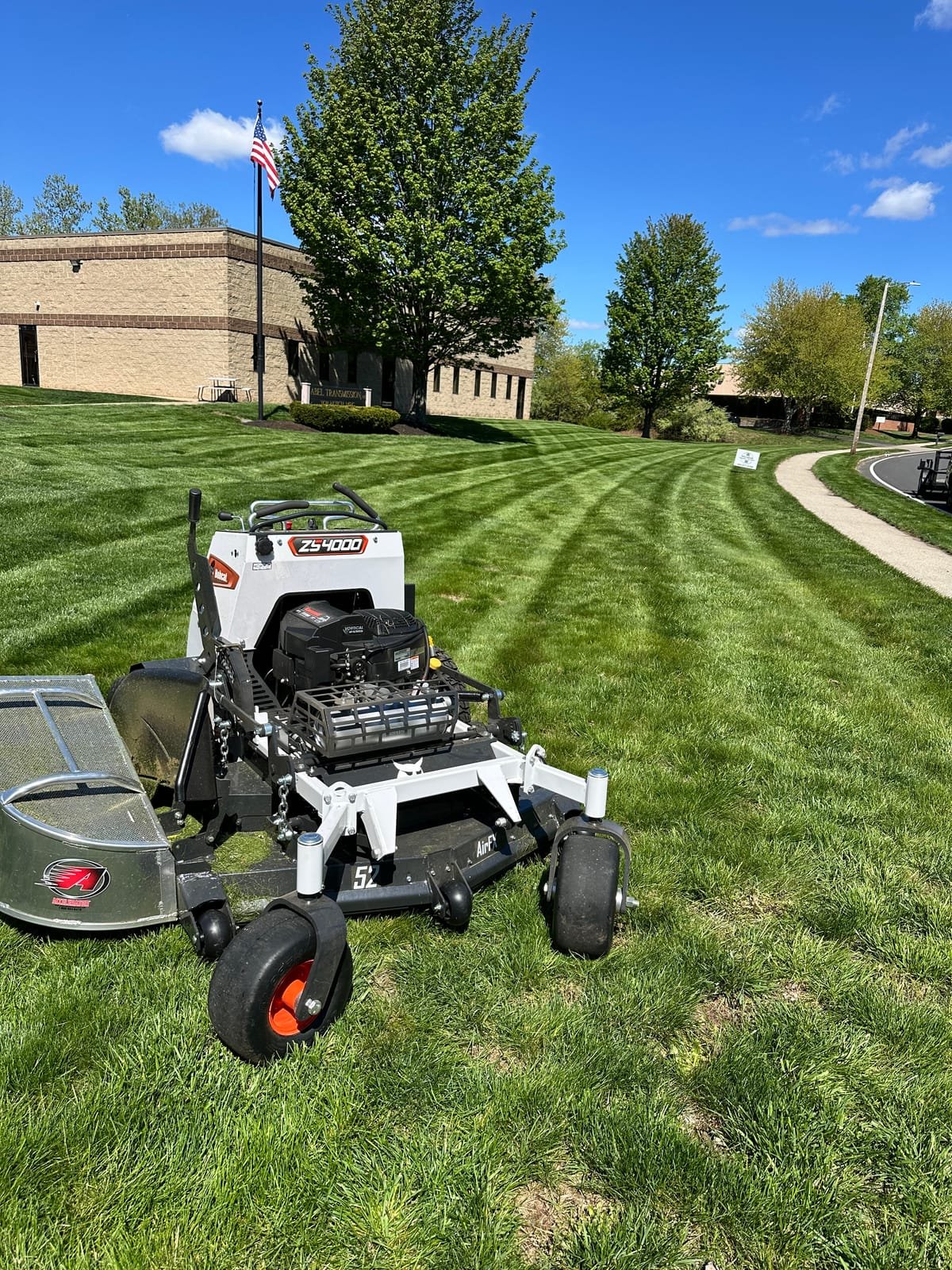 Zero-turn mower on a freshly striped lawn, ready for the next property